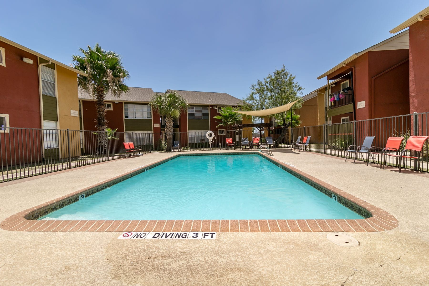 Apartments in San Antonio, TX - Fenced in Community Pool with Ample Seating and Shaded Area.